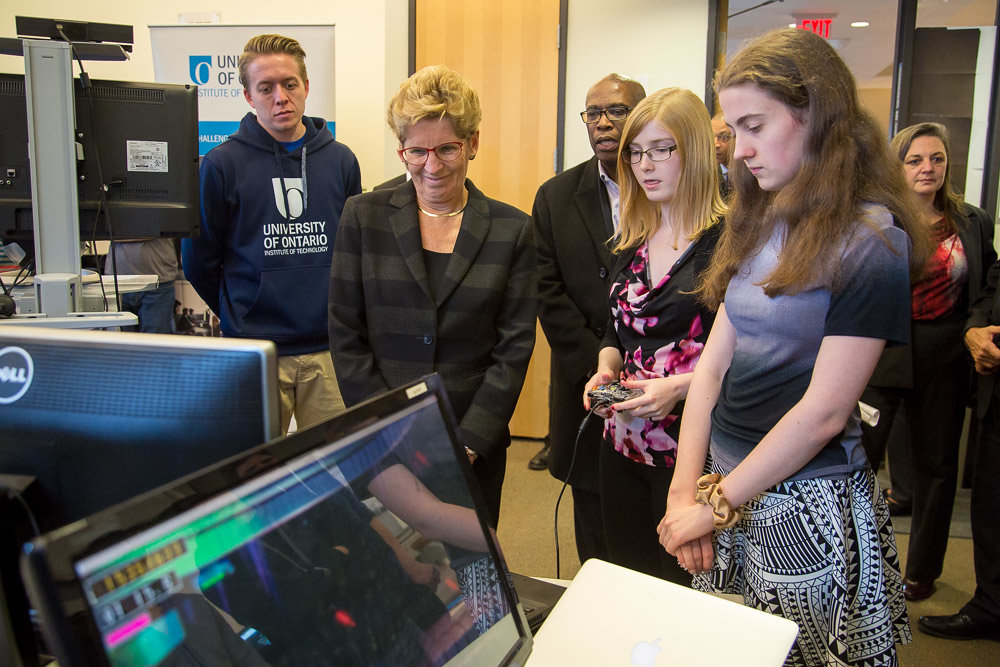 Premier Wynne watches demonstrations by students in the Faculty of Business and Information Technology's Games and Media Entertainment Research (GAMER) Lab.